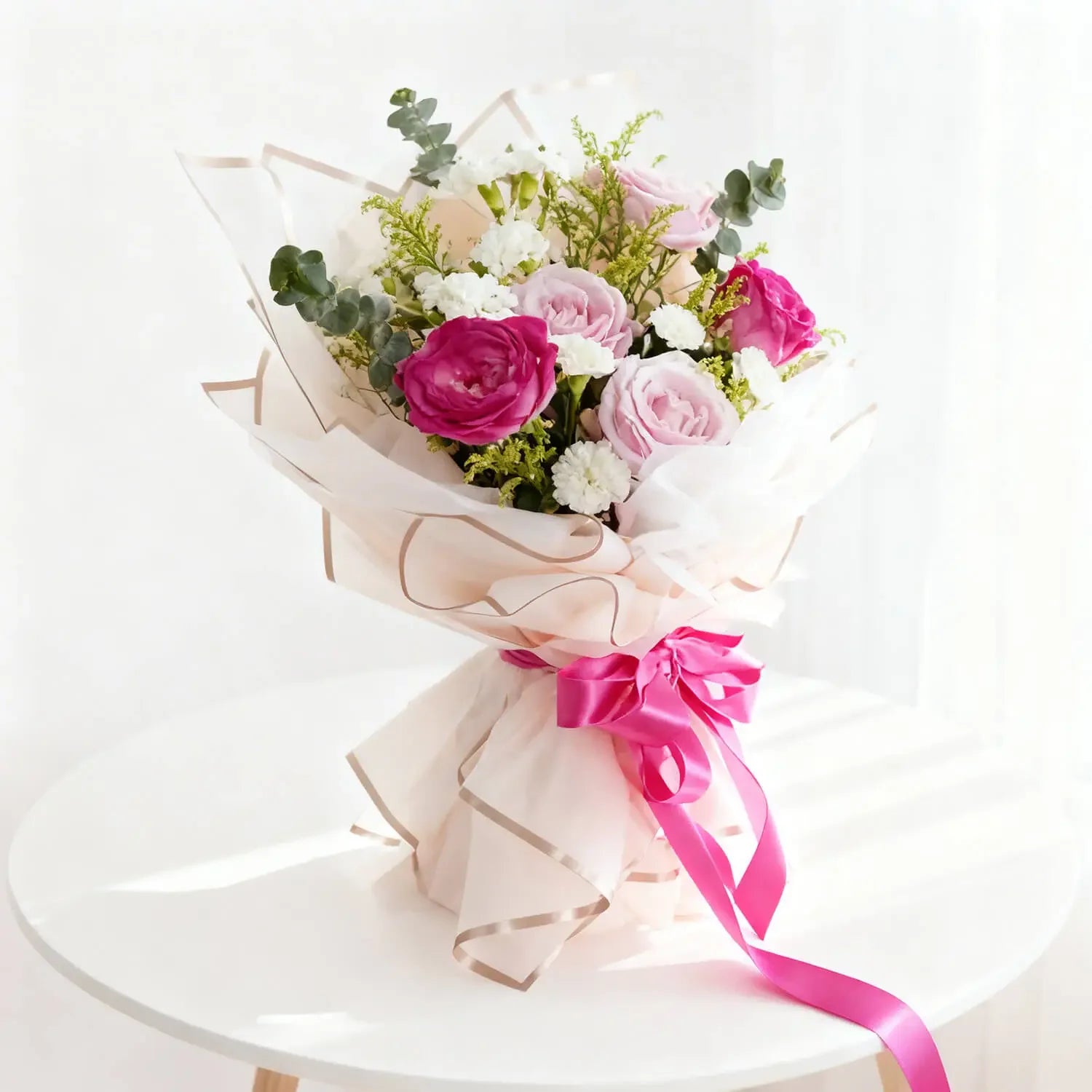 Buket bunga mawar pink dan putih elegan dari online florist, dibungkus kertas cantik dengan pita merah muda.