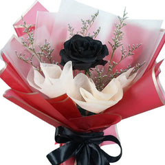Bouquet mawar hitam dan putih elegan dari online florist, dibungkus kertas merah dengan pita hitam