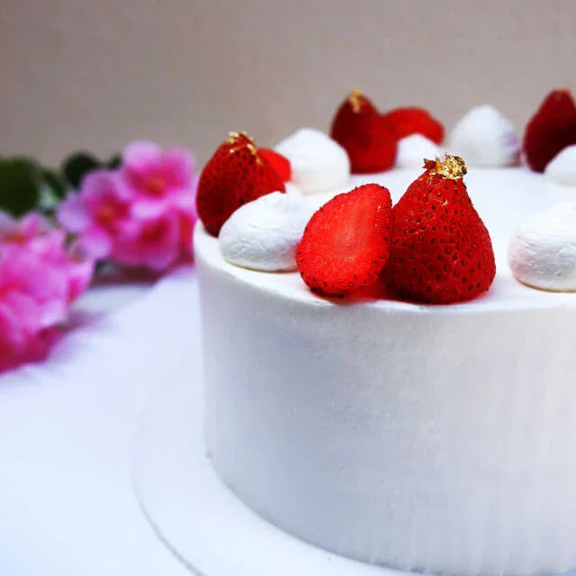 Kue putih dengan stroberi segar dan bunga pink, pesan online florist terpercaya
