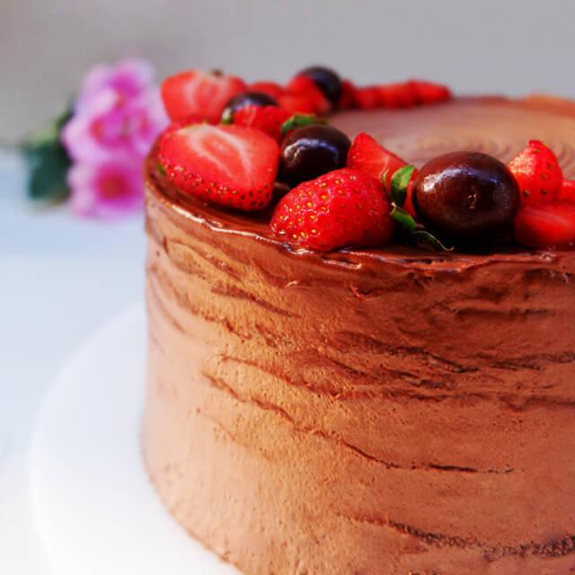 Kue cokelat lezat dengan stroberi dan ceri, pesan online dari online florist