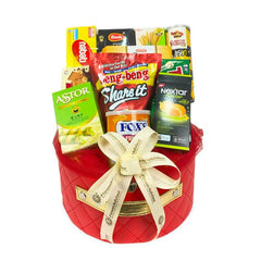 Hadiah makanan dalam keranjang merah dengan pita, ideal untuk dikirim oleh online florist