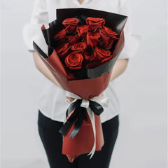 Buket mawar merah elegan dari online florist, dibungkus kertas merah-hitam dengan pita putih-hitam