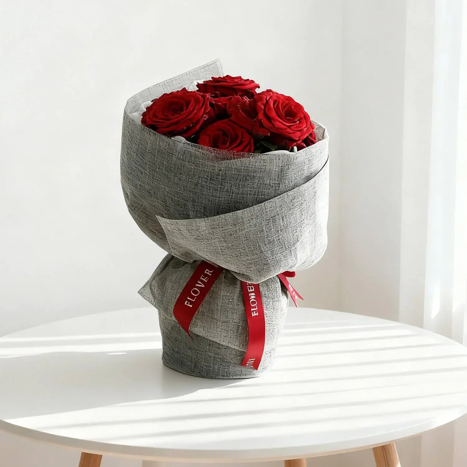 Bouquet mawar merah elegan dari online florist, dibungkus kain abu-abu dengan pita merah