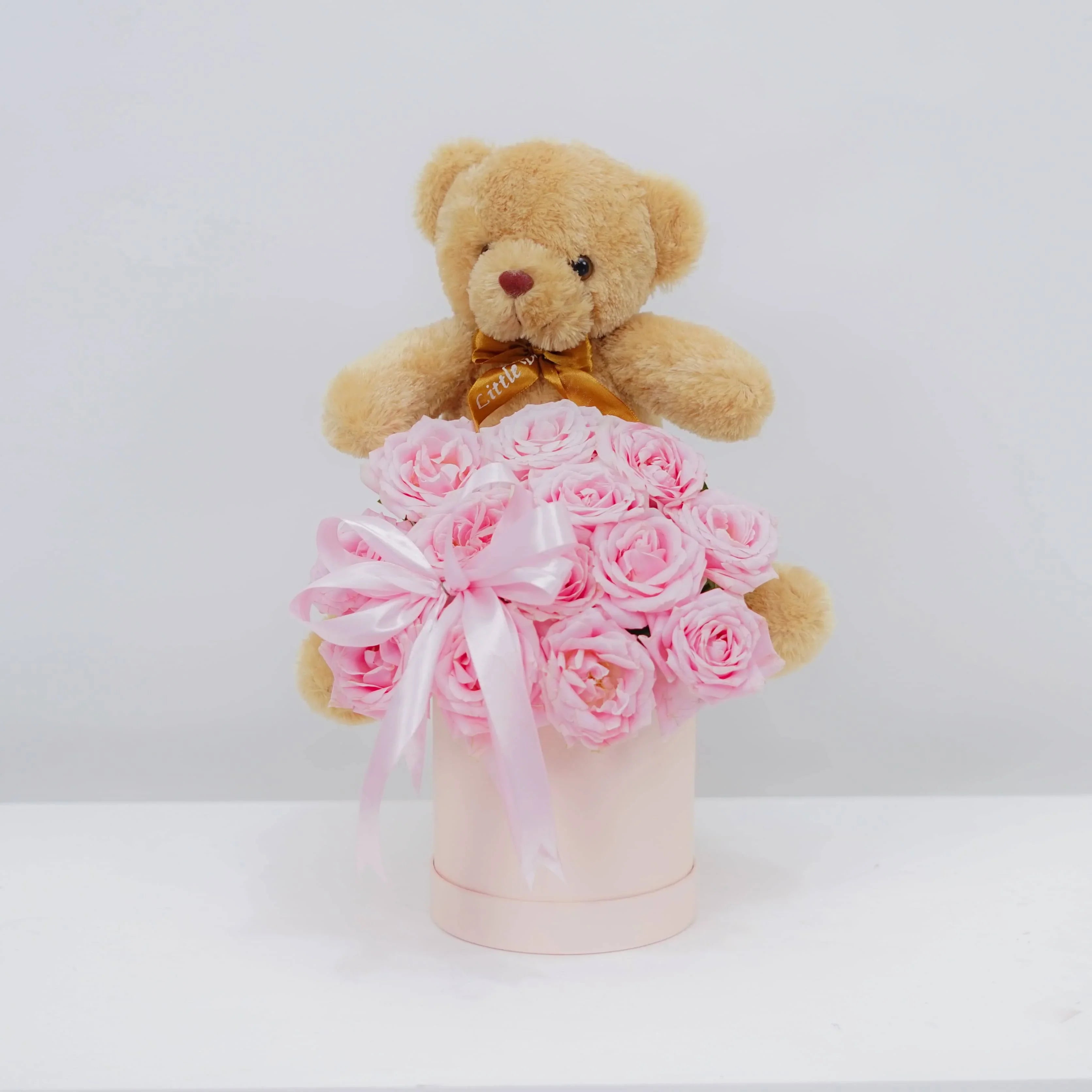 Bunga mawar pink cantik dengan boneka beruang di kotak hadiah, online florist