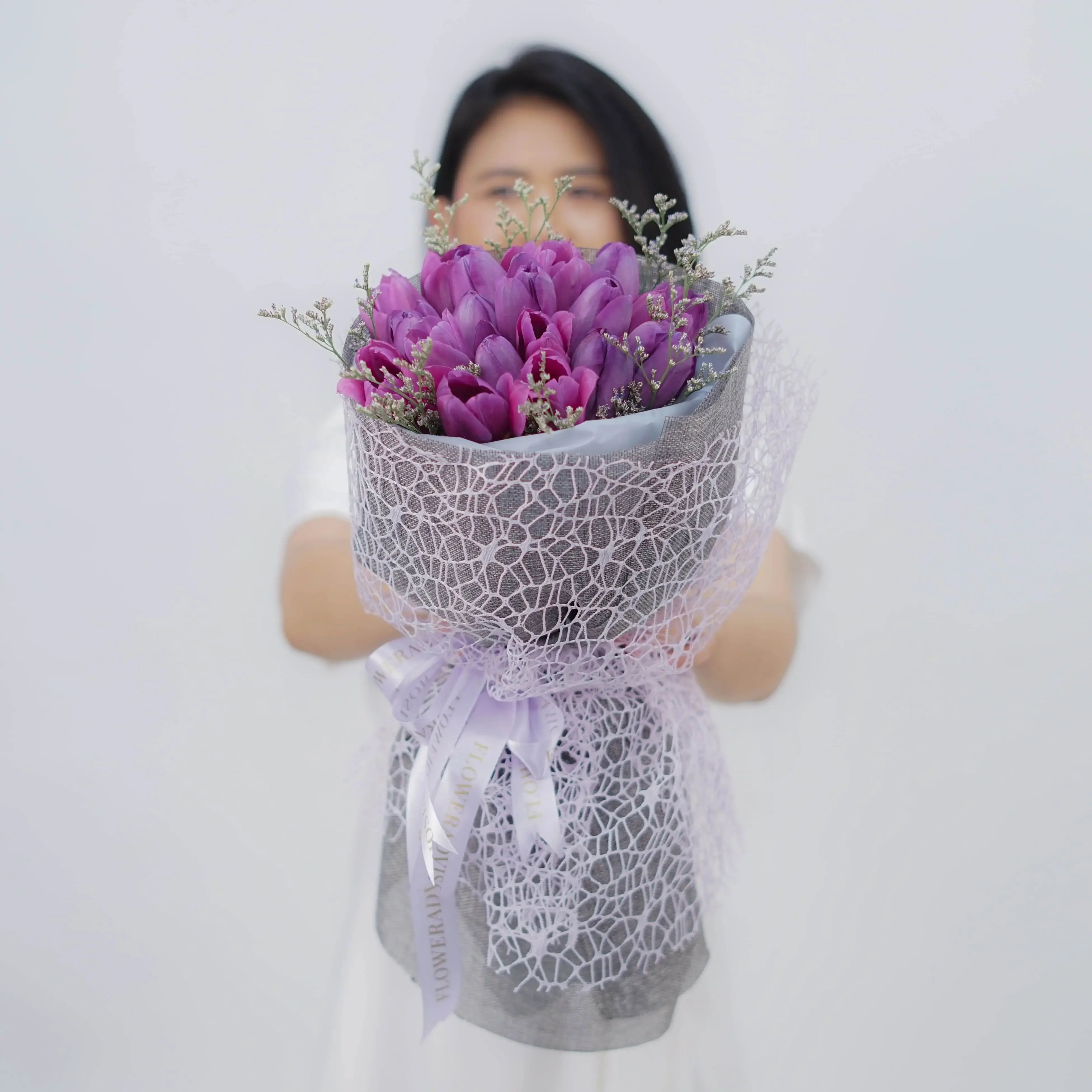 Bouquet bunga ungu elegan dari online florist, dikemas cantik dengan pita dan jaring halus