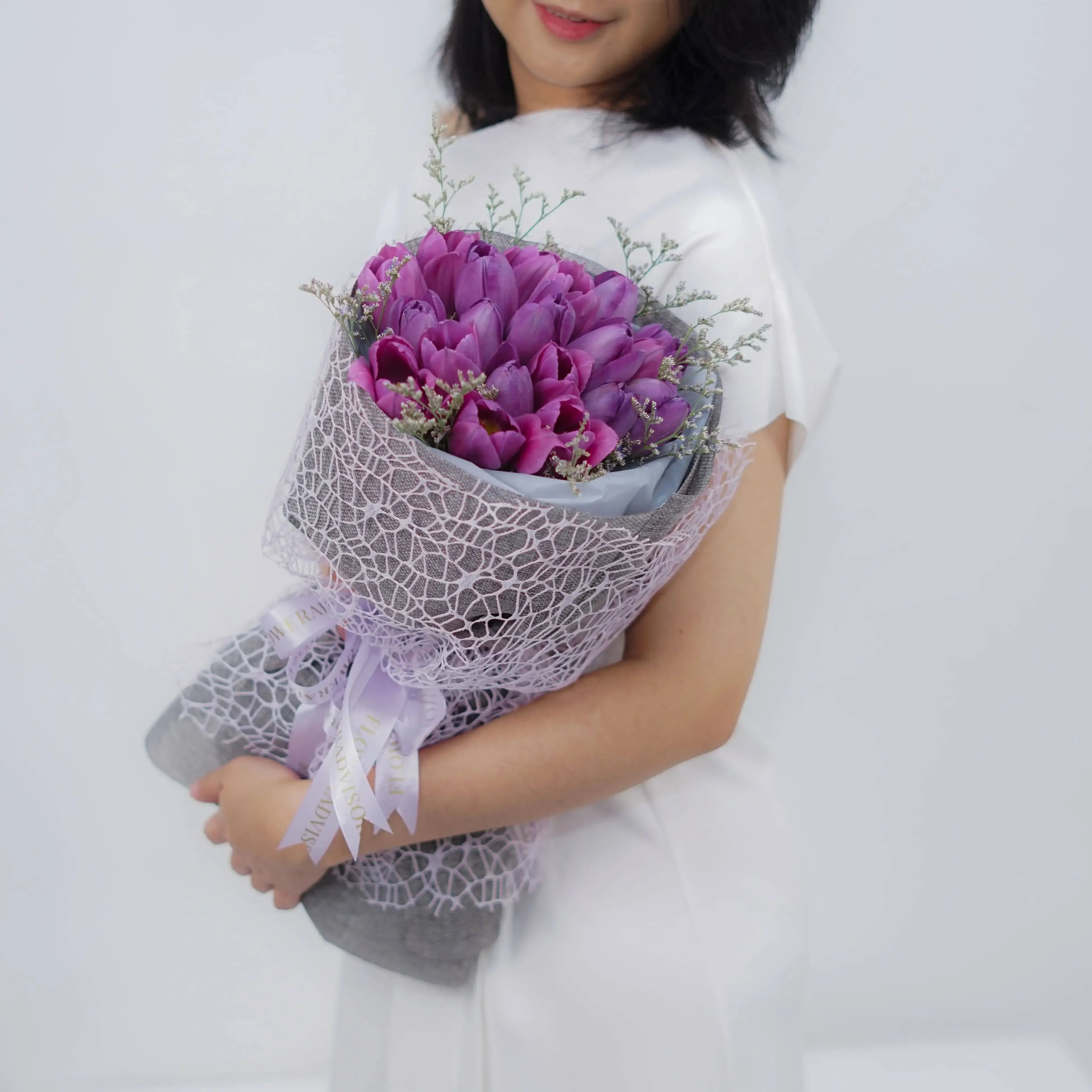 Bouquet bunga ungu elegan dari online florist, dikemas cantik dengan pita dan jaring halus