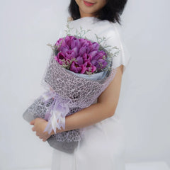Bouquet bunga ungu elegan dari online florist, dikemas cantik dengan pita dan jaring halus
