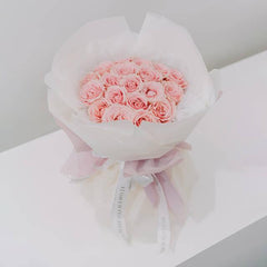 Buket mawar pink cantik dari online florist, dibungkus kertas putih dan pita elegan, siap dikirim.