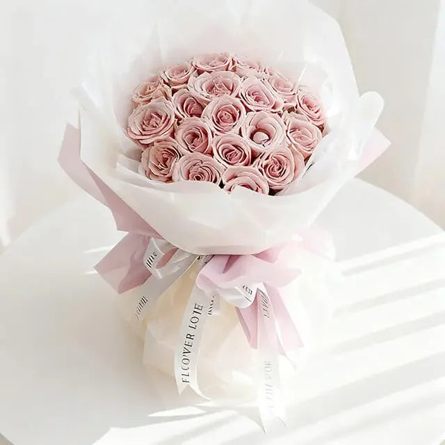 Bouquet mawar pink cantik dari online florist, dibungkus kertas putih dan pita elegan, ideal untuk hadiah.
