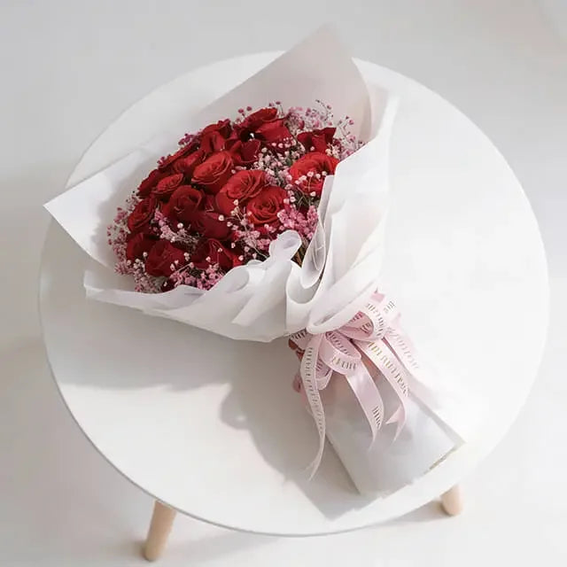 Buket mawar merah elegan dari online florist, dibungkus kertas putih dengan pita pink