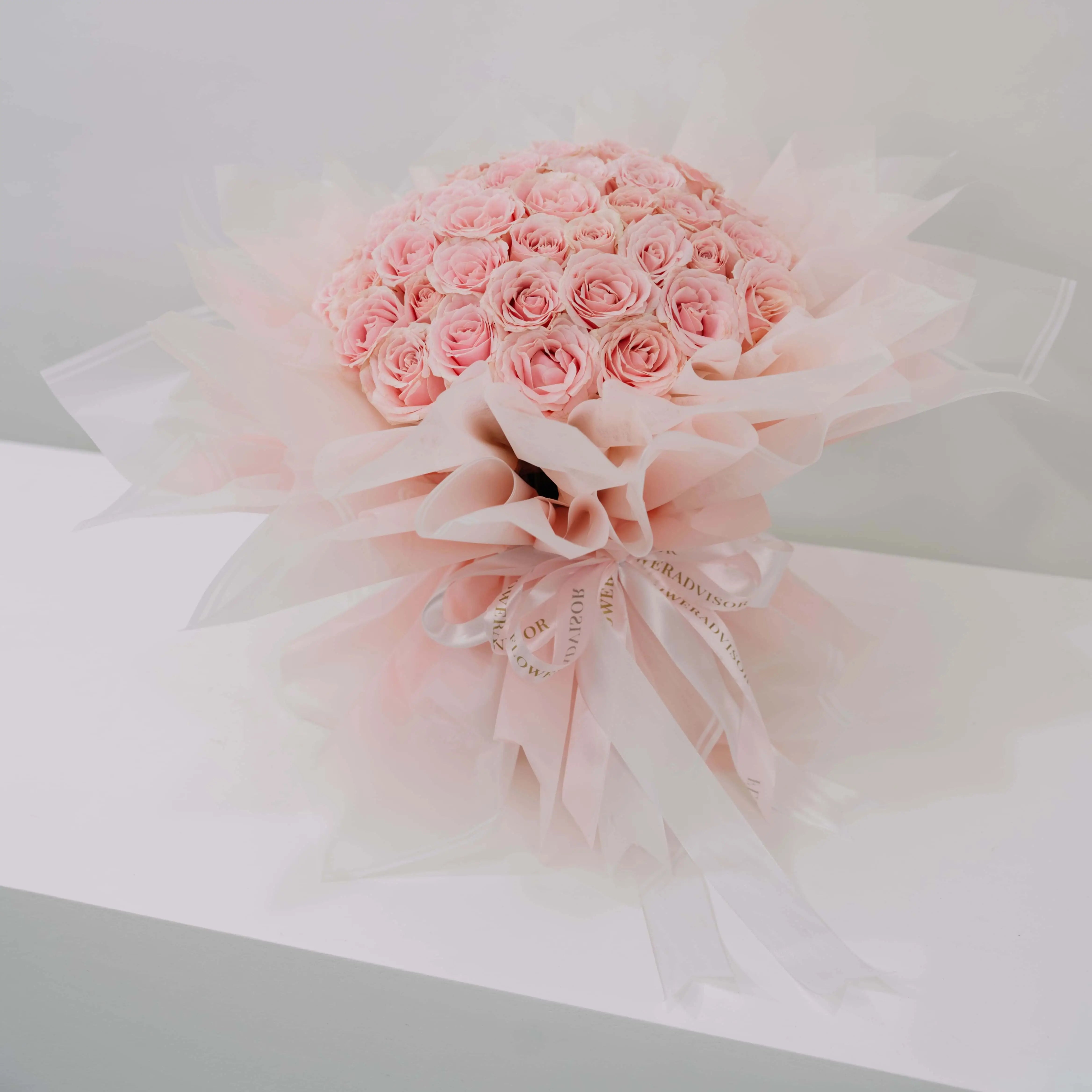 Bouquet mawar pink cantik dari online florist, dikemas elegan dengan pita dan kertas transparan.