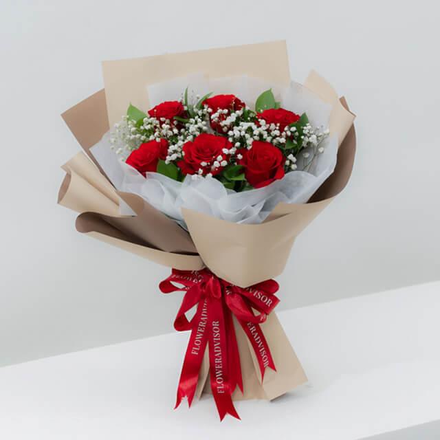 Bouquet mawar merah elegan dari online florist, dikemas rapi dengan pita merah