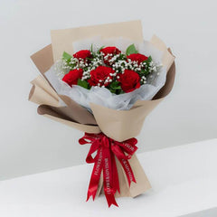 Bouquet mawar merah elegan dari online florist, dikemas rapi dengan pita merah
