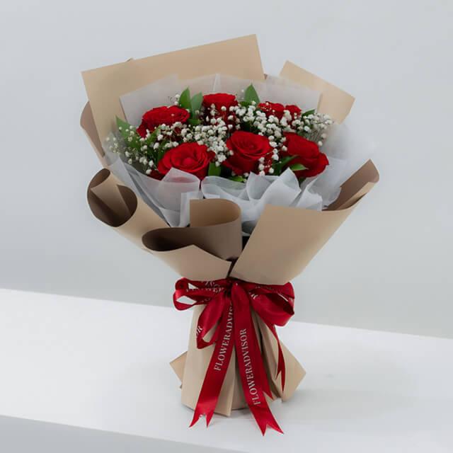 Bouquet mawar merah elegan dari online florist, dikemas rapi dengan pita merah