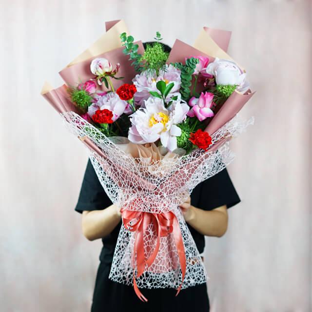 Buket bunga cantik dengan peony dan mawar, dikemas rapi untuk pengiriman dari online florist